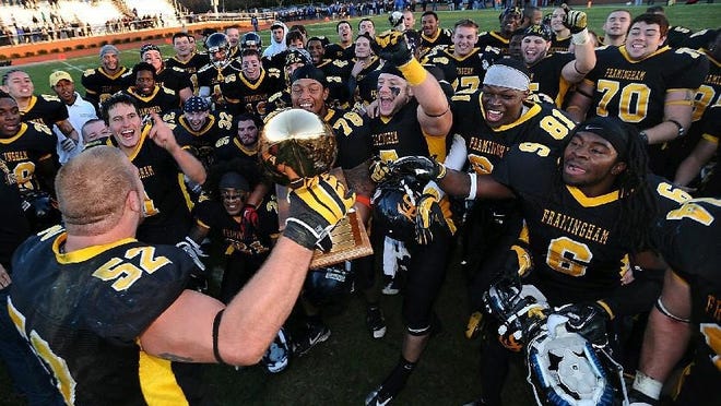 Framingham State's James Muirhead shows the team the New England Football Conference championship trophy after defeating Salve Regina at Bowditch Field in 2012.