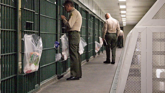 In this 2012 file photo, Los Angeles County sheriff's deputies inspect a cell block at the Men's Central Jail in downtown Los Angeles.