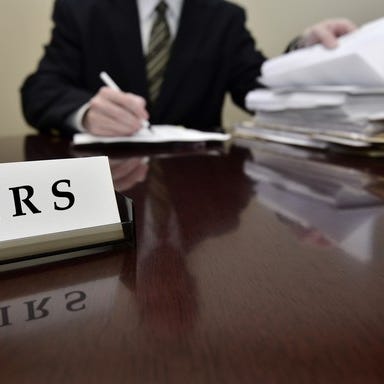 An IRS agent auditing taxes at his desk.