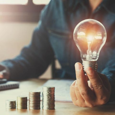 A man using a calculator while holding a light...