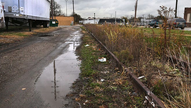 Selese Goss, 45, was found dead in this alley that runs East-West between the 2100 block of Columbia Street and Dr. Andrew J. Brown Avenue (background). The alley, shown on Thursday, Nov. 6, 2014, is adjacent to an abandoned Penn Central Railroad track.