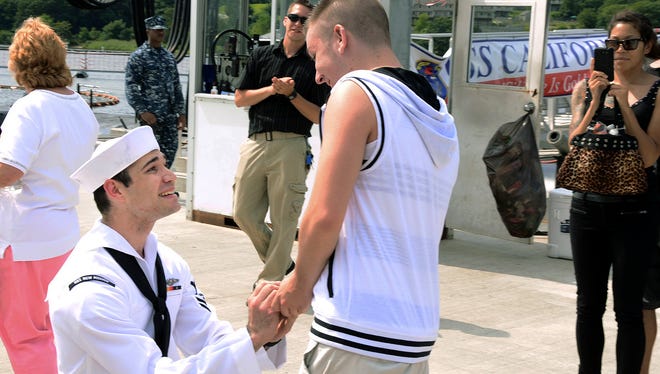 In this photo provided by the U.S. Navy, Petty Officer 2nd Class Jerrel Revels, left, proposes to his boyfriend Dylan Kirchner during the homecoming of the USS New Mexico at the submarine base in Groton, Conn., after the ship's inaugural six-month deployment.