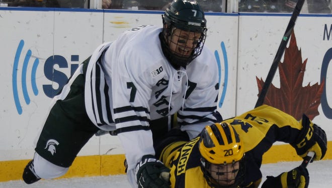 Michigan's Travis Lynch is held down by Michigan State' s John Draeger on Dec. 28,  2013.
