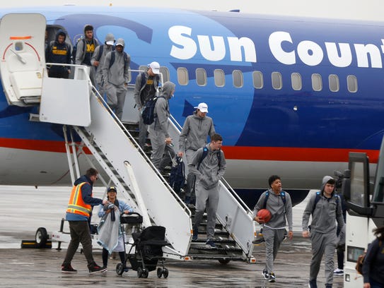 The Michigan basketball team exits its plane at Willow