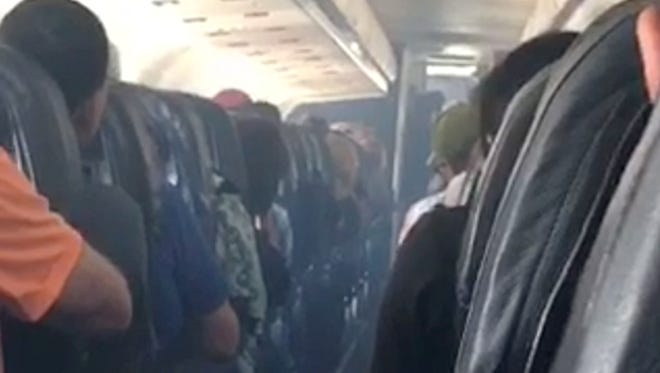 This frame from mobile phone video shows smoke inside an Allegiant Air jet after it landed at Fresno Yosemite International Airport in California's Central Valley, Monday, Sept. 25, 2017. Smoke filled the cabin of an Allegiant Air jet after it landed at the airport on Monday, forcing coughing passengers to cover their faces with shirts and firefighters to board the plane, authorities said. Allegiant said no passengers or any of the six crew members were injured. (Estevan Moreno via AP)