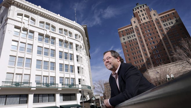 Paul Foster stands by two of his Downtown properties: the Plaza Hotel building, right, and the Centre Building.