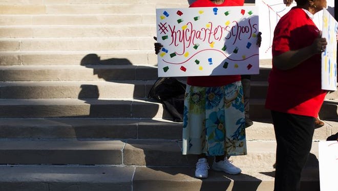 Pat Johnson holds a sign during a rally on the steps of City Hall in downtown Louisville.