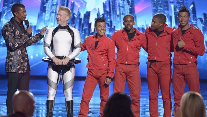 Jason Whicker, second from left, chats with "America's Got Talent" host Nick Cannon following Tuesday's performance by Mothmen Dance.