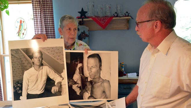 Joy (Ufema) Counsel and Dr. David Hawk show some of the many photographs taken by Jack Radcliffe at the York House Hospice in the mid-1990s.