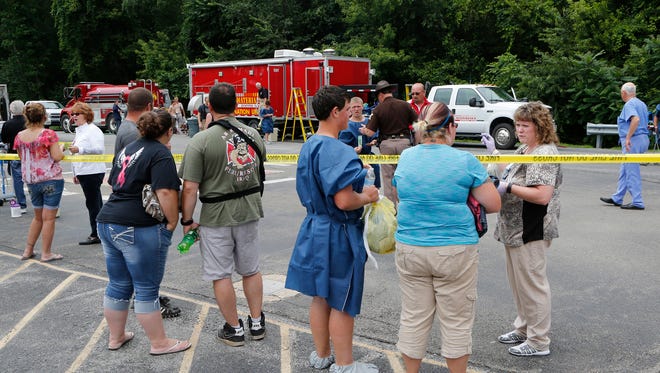 Teenagers exposed to fungicide are treated by the Tippecanoe County Emergency Management Agency Hazardous Materials Response Team's decontamination unit Wednesday, July 15, 2015, in the parking lot of St. Vincent Williamsport Hospital. About 25 teenagers detasseling corn near Judyville were exposed to fungicide after a crop-duster's spray drifted over the field they were working.