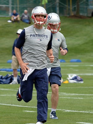 New England Patriots quarterback Tom Brady jogs Tuesday during organized team activities at Gillette Stadium in Foxborough, Mass.