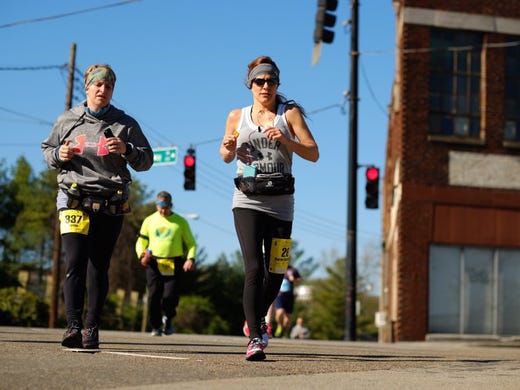 Full-marathon runners, from left, Karrie Mullins-Potter of Wise, VA. (337), and Karen Barnett of Wise, VA. (26), run onto North Broadway during the 2016 Covenant Health Knoxville Marathon on Sunday, April 3, 2016. 