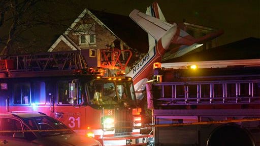 A small twin-engine cargo plane is seen after it crashed into a home on Chicago's southwest side early Tuesday morning, Nov. 18, 2014, shortly after taking off from Midway International Airport. A fire department spokesman says two occupants of the home were unhurt. Authorities did not immediately release information about the pilot's condition. (AP Photo/Sun-Times Media, Brian Jackson) 