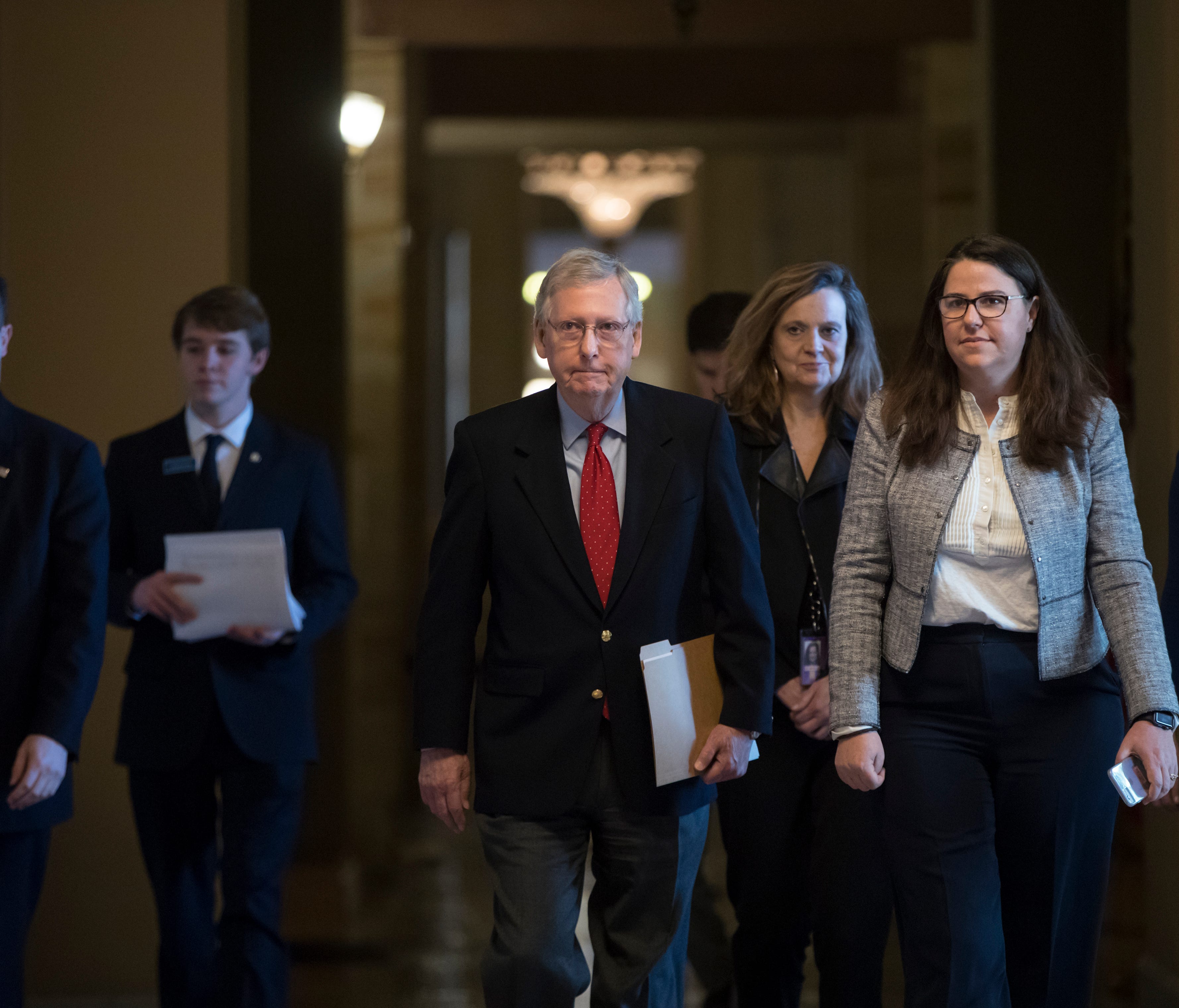 Senate Majority Leader Mitch McConnell, R-Ky., walks to the chamber on the first morning of a government shutdown Saturday, Jan. 20, 2018.