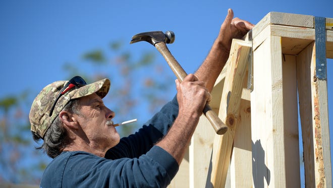 Construction worker David Rager, 53, frames the upper floor of a two-story custom home being built in Orlando, Fla., in February.