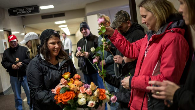 Mara McCalmon, a victims rights advocate and founder of the nonprofit P.S. You're My Hero, hands out flowers to participants before a 2017 ceremonial flower toss in honor of National Crime Victims' Rights Week at the St. Clair County Courthouse.