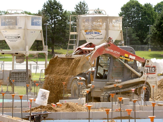 Contractors backfill the foundation for a concessions