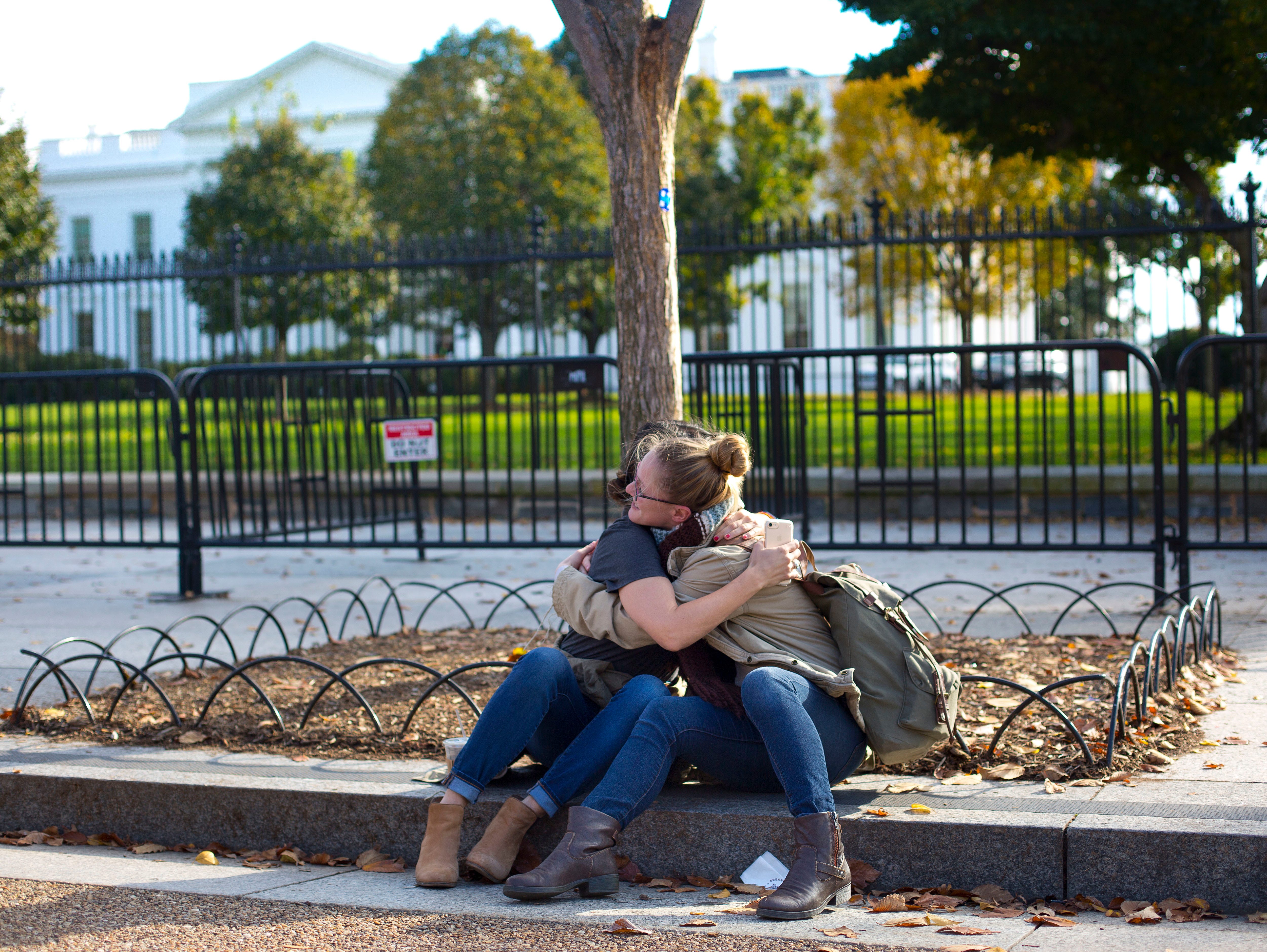 Jennie Armstrong, left, and Krister Cheriegate hug in front of the White House on Wednesday. The two women don't know each other but when Cheriegate saw Armstrong getting emotional she ask her is she need a hug.