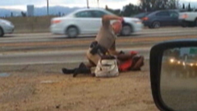 Image made from video provided by a motorist shows a California Highway Patrol officer punching a woman on the shoulder of a Los Angeles freeway.
