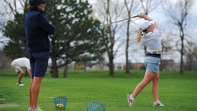 Augustana's Emily Israelson hits her ball on the driving range as coach Peggy Kirby looks on before playing a round of golf Thursday, April 21, 2016, at Kuehn Golf Course in Sioux Falls.