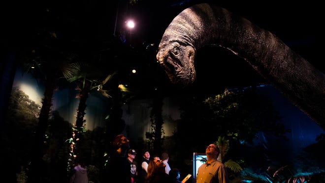 A man looks up at an animatronic Brachiosaurus as The Franklin Institute unveils a new 'Jurassic World' exhibit last Friday in Philadelphia.