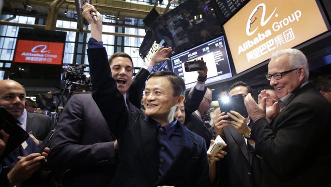 Alibaba founder Jack Ma, center, raises a ceremonial mallet before striking a bell during the company's IPO at the New York Stock Exchange on Sept. 19, 2014.