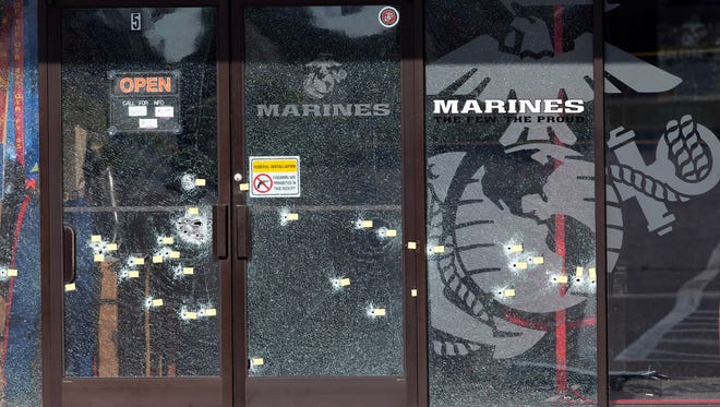 Yellow pieces of paper mark bullet holes in the glass at a military recruiting center July 17, 2015, in Chattanooga, Tenn. Muhammad Youssef Abdulazeez of Hixson, Tenn., attacked two military facilities the day before in a shooting rampage that killed four Marines.