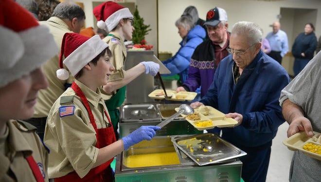 Boy Scout Troop 20 members including Peter Doroff, left center, 13, dish up portions for the annual Christmas dinner, now in its 30th year, Friday, Dec. 25 at St. Joseph Catholic Church in Waite Park.