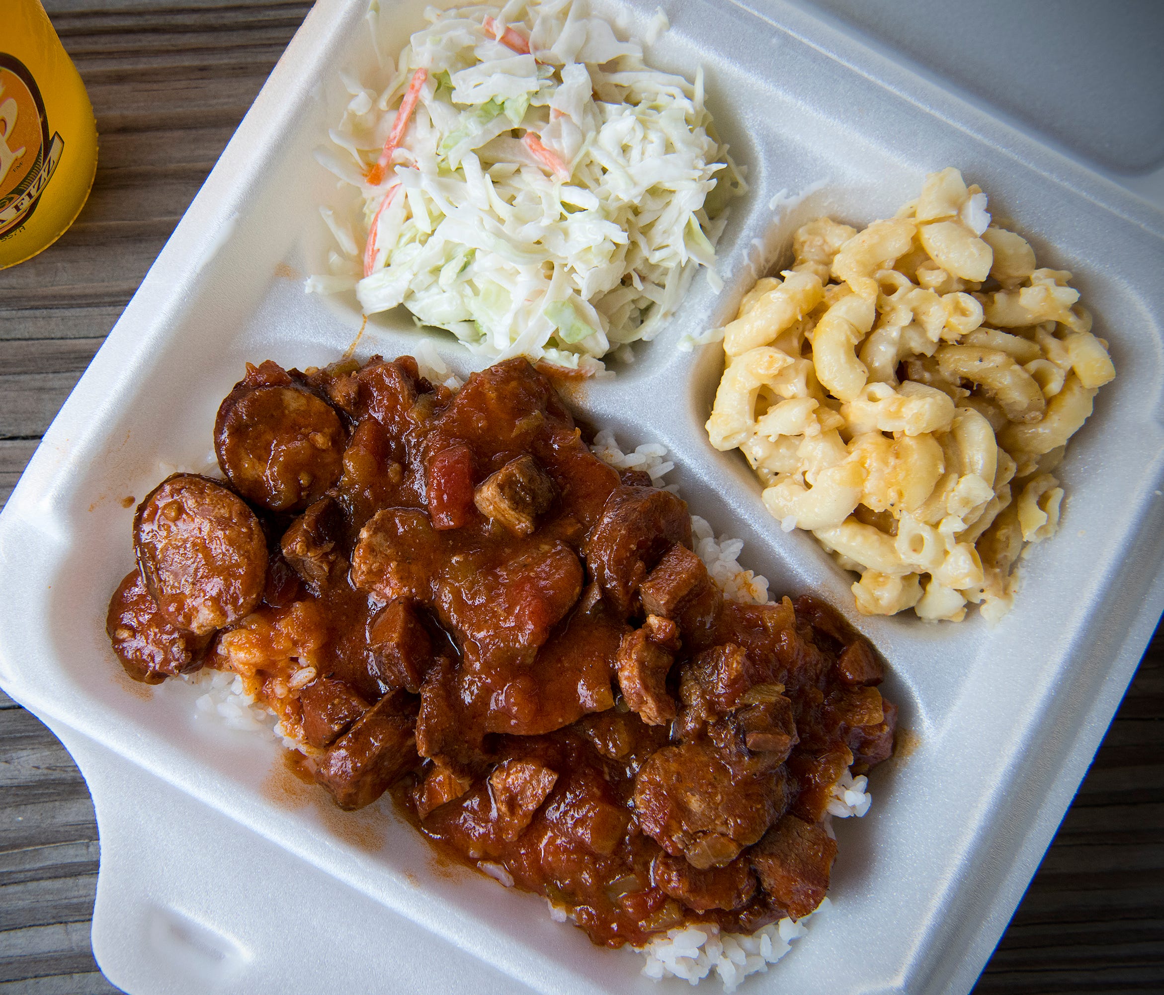 A crowd pleaser in these parts is the popular plate lunch, consisting of a main entree and two sides. In this case it's a serving of smoked sausage and tasso in red sauce over rice with sides of coleslaw and mac and cheese at Johnson's Boucaniere.
