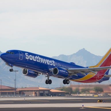 A Southwest airplane takes off from a runway.