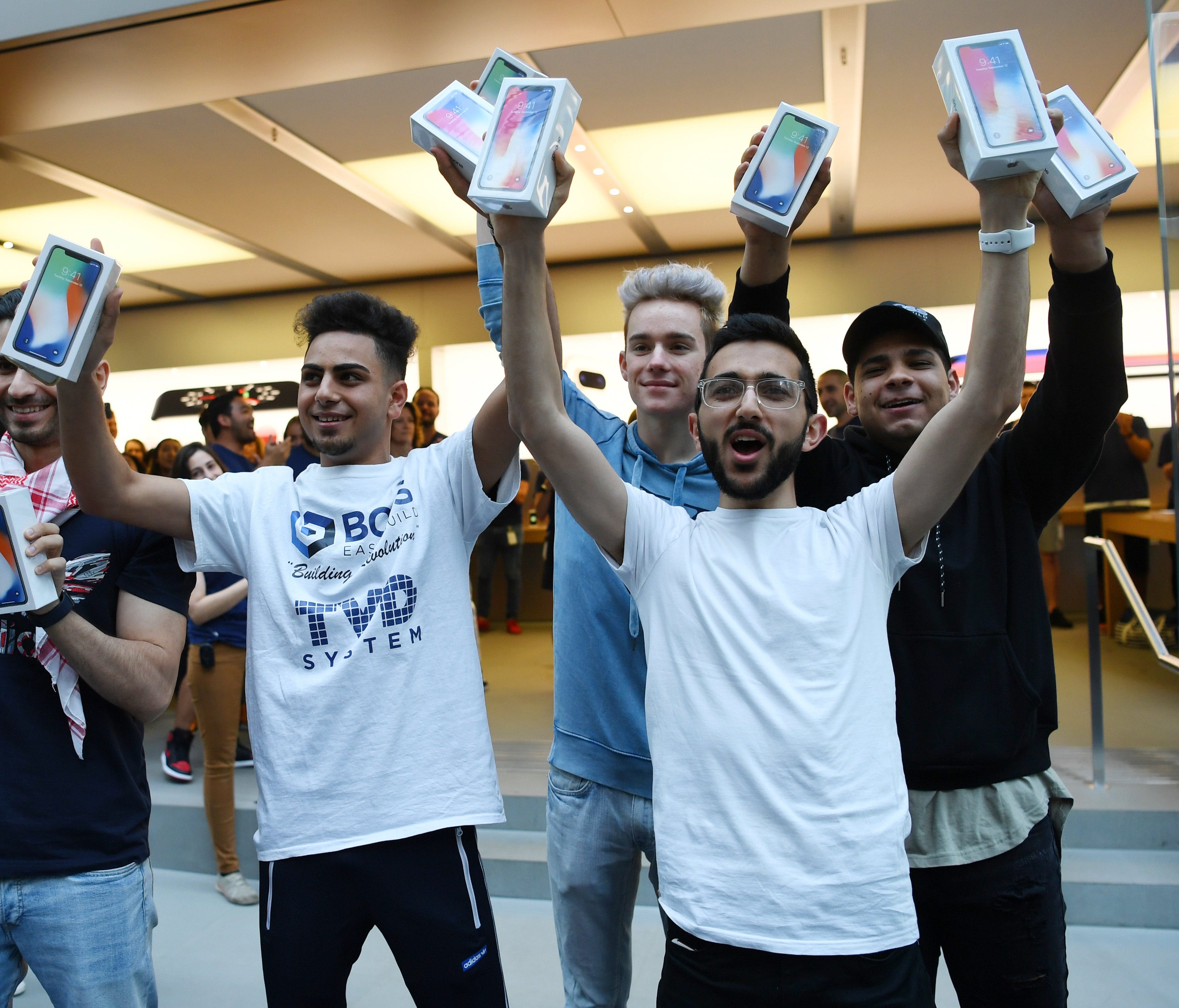 The first purchasers of the iPhone X show off their boxed phones to the media after its release to the public outside the Apple Store in Sydney, Australia.