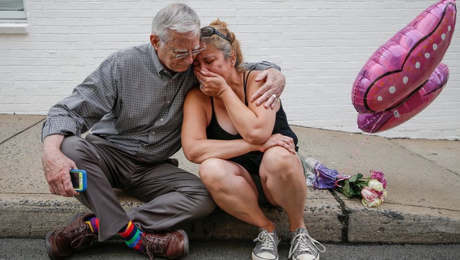 Charlottesville resident Mai Shurtleff, right, sits weeping on the sidewalk near the site where on Saturday a car plowed into a group of counter protesters killing one. "This wasn't something I expected to happen in our town," she said, as Charlottesville resident Bob Kiefer consoled her on August 13, 2017. "This does not define Charlottesville at all. We are a strong, loving community. I don't even know this gentleman but as strangers we are friends. This is what makes us stronger together."