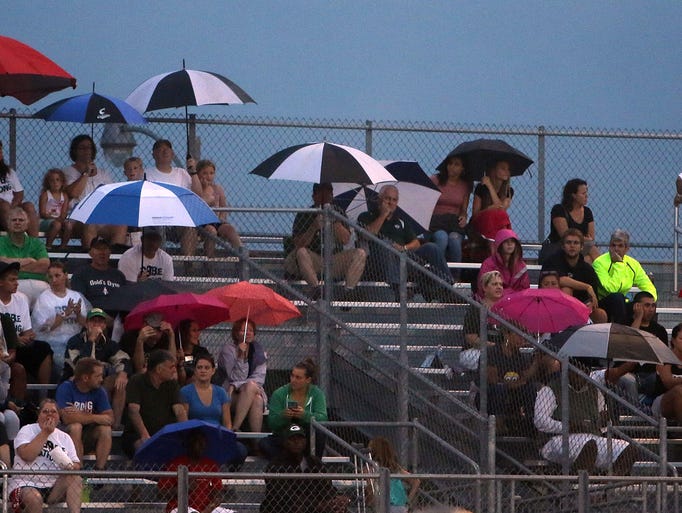 Wauwatosa West fans take shelter from the rain during