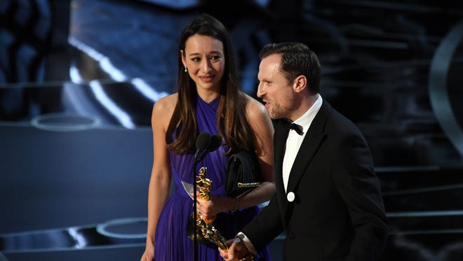 Producer Joanna Natasegara and director Orlando von Einsiedel accept the Oscar for best documentary short subject for 'The White Helmets'.'