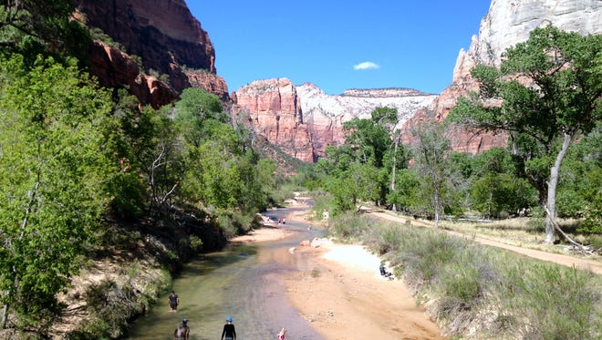 Visitors wade through the Virgin River where it passes through the main canyon near the Zion Canyon Lodge at Zion National Park on May 18.
