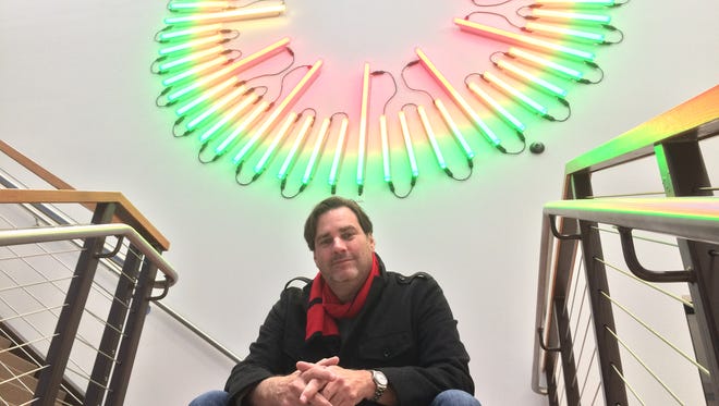 Artist James Ellwanger of Des Moines designed and installed the 20-foot clock in the lobby of 300MLK. He sat for a photo at 8:49 p.m. Thursday.