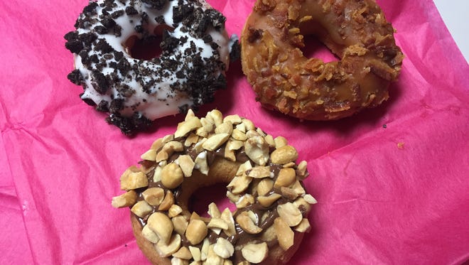 Doughnuts include cookies and cream, maple glaze and bacon topping, Nutella and peanuts.