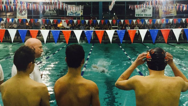 Members of the El Paso High boys 400 freestyle relay team watch as a teammate makes his way down the lane Thursday.