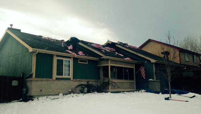 Workers repair the roof of a home in Loveland.