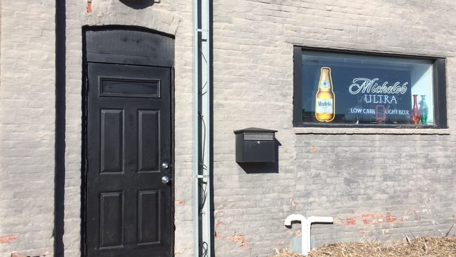 An unmarked side door at Ceviche Bar leads to a basement where Black Sheep speakeasy operated the past two weekends in Des Moines' East Village. A symbol with two red crosses appears above the door when the bar is open.