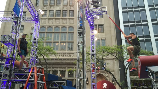 IMPD Officer Pete Koe swings past the first obstacle of the "American Ninja Warrior" course on Monument Circle in 2016, but fell in the water shortly after.