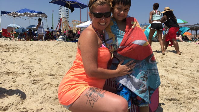 This May 28, 2016, photo is of New Church, Va., residents Renee Bielli and her son, Matthew, 7, enjoy warm temperatures and chilly ocean waters at Ocean City.