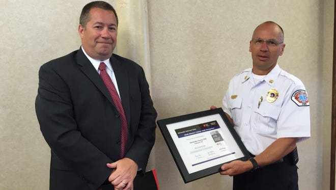 Alex Kuhn, director of quality for the American Heart Association, presents Sandusky County EMS Director Jeff Jackson with a Mission Lifeline Award for the county’s ability to respond to heart emergency calls.