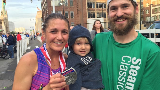 Former women’s half marathon winner Sarah Boyle, husband Ian and 2-year-old son Ayden after her third-place finish on Sunday.