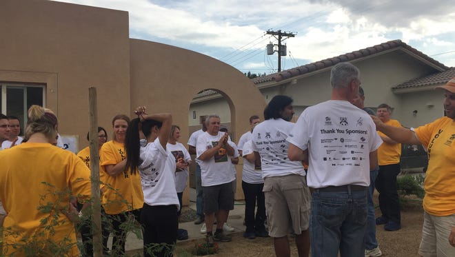 Volunteers receive instructions outside a Habitat for Humanity home that was being refurbished in La Quinta.