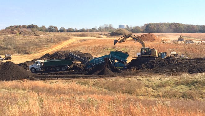 The process of a previously unusable material being screened into top soil after composting for 10 years.