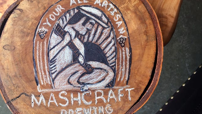 The MashCraft Brewing logo on old logs in used for decoration at the brewery's new Downtown location.