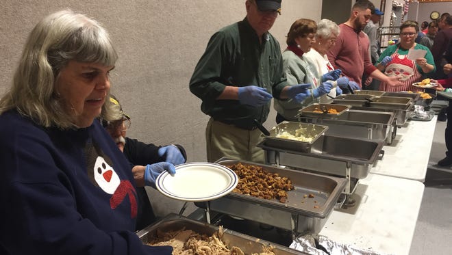Volunteers plate food at the Salvation Army's Christmas Dinner on Christmas Day 2016. Dinner organizer Lynne Newcomer estimated 700 people would come through