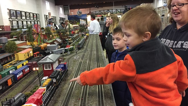 Laken Cooley, 4, points to a model train at the 20th annual Cumberland Valley Model Railroad Club Model Train Show as his cousin Colton Hunsecker, 9, and his aunt Wanda 
Baughman-Hunsecker look on.