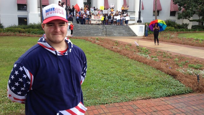 William Gentry, a senior at Leon High School, shows his American pride as anti-Trump  activists gather Friday at the Old Capitol.
